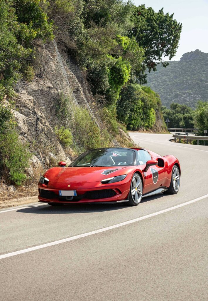Ferrari 296GTS driving on the road to Porto Cervo.